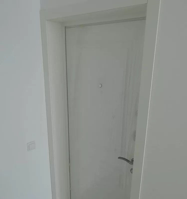 Белая входная дверь с белой дверной коробкой
